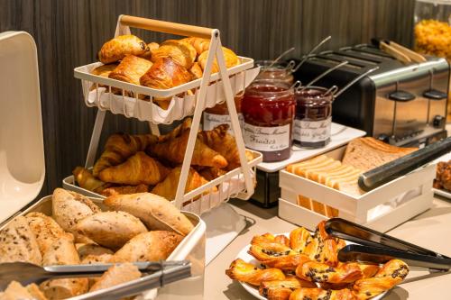 a buffet with various types of bread and pastries at ibis Styles Saint-Quentin in Saint-Quentin