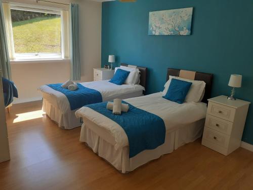 two beds in a room with blue walls at Beach view in Spittal