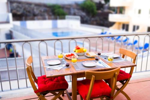 a table with food and fruit on top of a balcony at Poseidón Arena Beach in Puerto de Santiago
