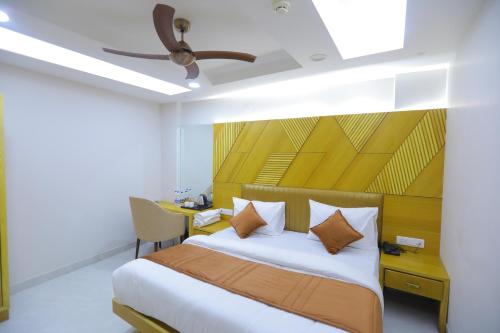 um quarto com uma cama e uma ventoinha de tecto em Hotel The Glitz em Nova Deli