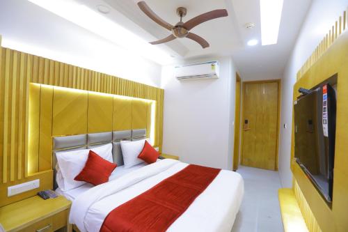a bedroom with a large bed and a flat screen tv at Hotel Glitz - Walk in from New Delhi Railway Station in New Delhi
