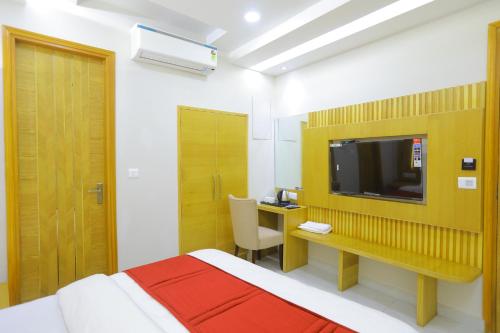 a bedroom with a bed and a desk with a television at Hotel Glitz - Walk in from New Delhi Railway Station in New Delhi