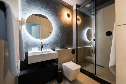 a bathroom with a sink and a toilet and a mirror at Ultramarinn Hotel in Odesa