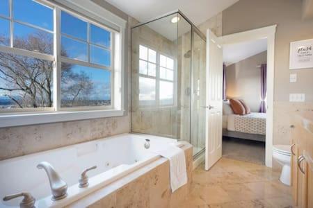 a large bathroom with a tub and a window at Fremont home with panoramic views near Woodland Zoo in Seattle