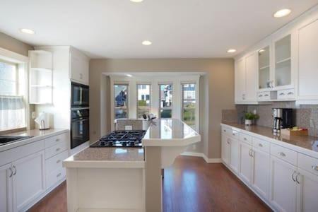 a large kitchen with white cabinets and a stove at Fremont home with panoramic views near Woodland Zoo in Seattle