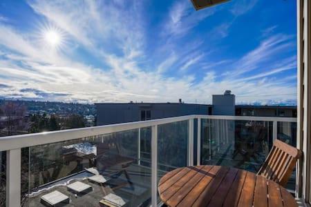a balcony with a wooden table and chairs on it at Fremont home with panoramic views near Woodland Zoo in Seattle
