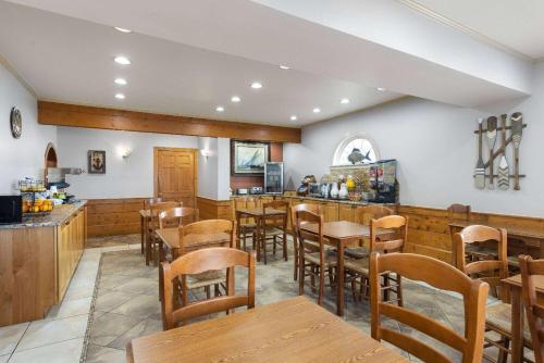 a restaurant with wooden tables and chairs and a bar at Days Inn by Wyndham Kill Devil Hills Oceanfront - Wilbur in Kill Devil Hills