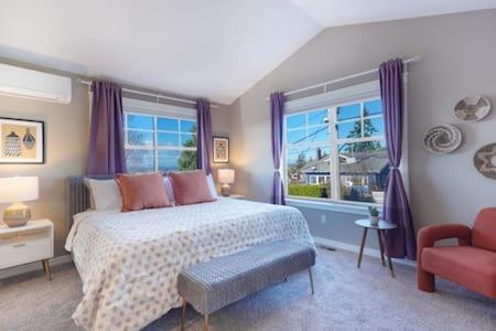 ein Schlafzimmer mit einem Bett, einem Stuhl und einem Fenster in der Unterkunft Fremont home with panoramic views near Woodland Zoo in Seattle