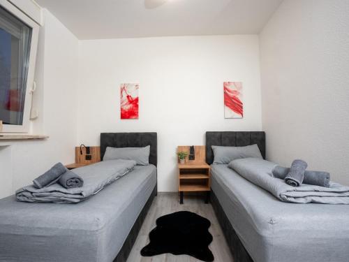 dos camas sentadas una al lado de la otra en una habitación en SR24 - gemütliches Apartment 2 in Recklinghausen, en Recklinghausen