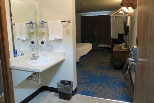 a bathroom with a sink and a room with a bed at Days Inn by Wyndham Alamosa in Alamosa