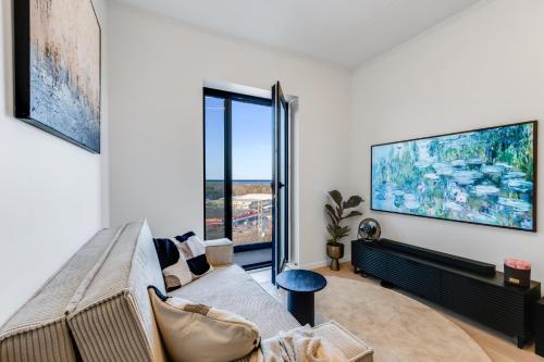 ein Wohnzimmer mit einem Sofa und einem großen Fenster in der Unterkunft Sea view 16 floor premium apartment in Tallinn
