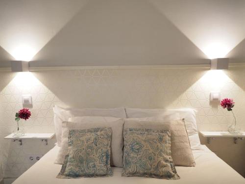 a white bed with two pillows in a bedroom at Tranquilidad en el corazón de Madrid. in Madrid