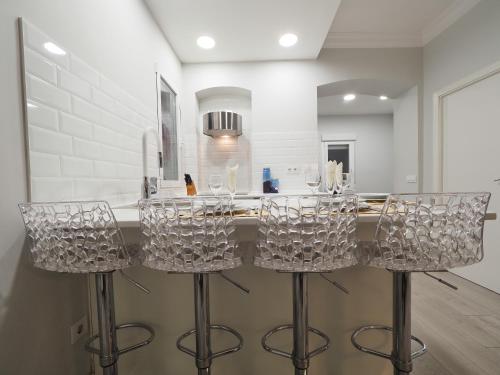 a kitchen with clear bar stools in front of a counter at Tranquilidad en el corazón de Madrid. in Madrid