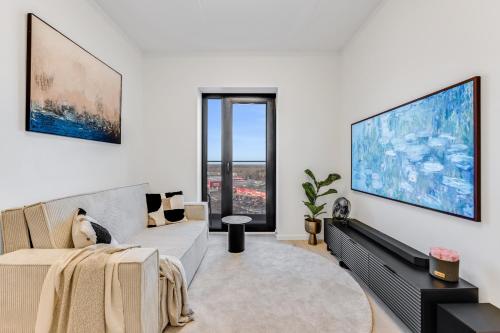 een woonkamer met een bank en een tv bij Sea view 16 floor premium apartment in Tallinn