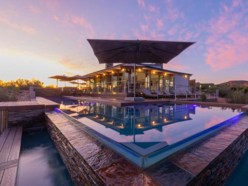a house with a pool in front of a building at Landrani Farmstay in Oudtshoorn
