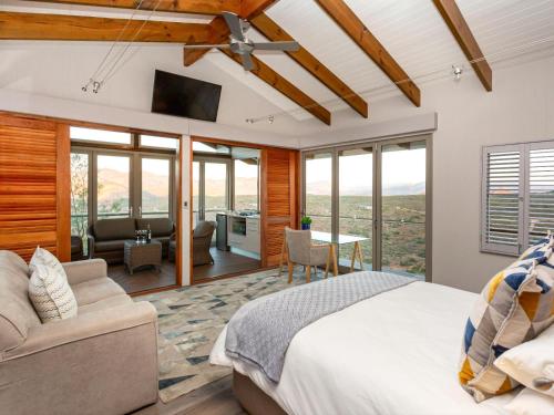 オーツホーンにあるLANDRANI Luxury Self-catering Accommodationのベッドルーム1室(ベッド1台付)、リビングルームが備わります。