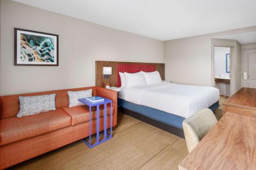 a hotel room with a bed and a couch at Hampton Inn Ft. Lauderdale-Cypress Creek in Fort Lauderdale