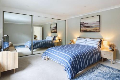 a bedroom with two beds and a large mirror at The Dolman at Ferndown Forest Golf Course in Ferndown