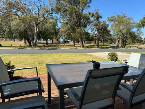 a table and chairs on a deck in a park at Pelicans' Retreat Falcon in Falcon
