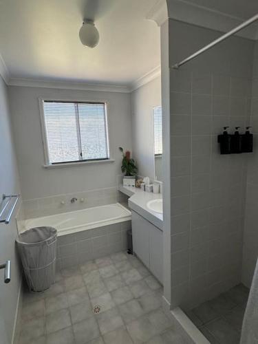 a white bathroom with a tub and a sink at Pelicans' Retreat Falcon in Falcon