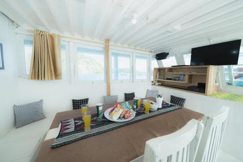 a dining room with a table and a television at Arimbi Liveaboard in Labuan Bajo