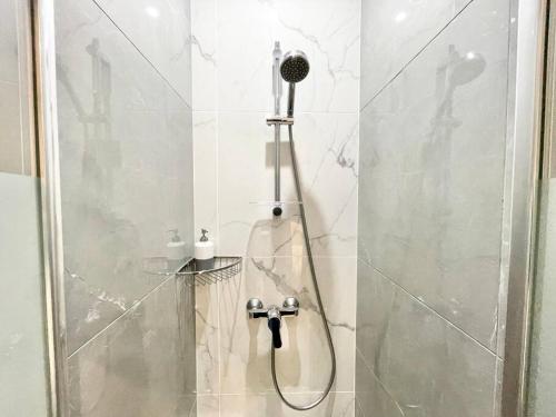 a shower with a shower head in a bathroom at Charming Studette Paris La Défense in Puteaux