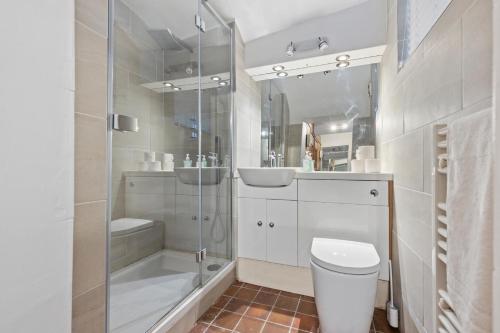 uma casa de banho com um chuveiro, um WC e um lavatório. em Heavenly Stays - Victoria em Londres