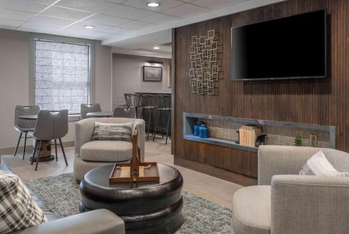 a waiting room with a flat screen tv on a wall at The Inn at Burlington, Trademark Collection by Wyndham in Burlington