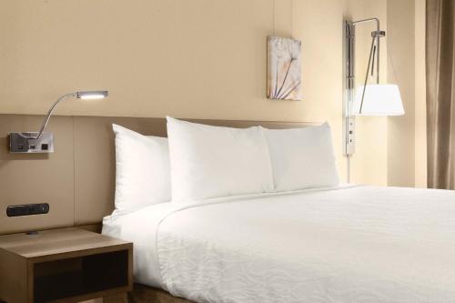 a bed with white sheets and pillows in a hotel room at Hilton Garden Inn Charlotte Southpark in Charlotte