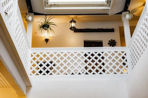 a staircase in a house with a white stair railing at Emerald Palm Courtyard Hotel in Zanzibar City