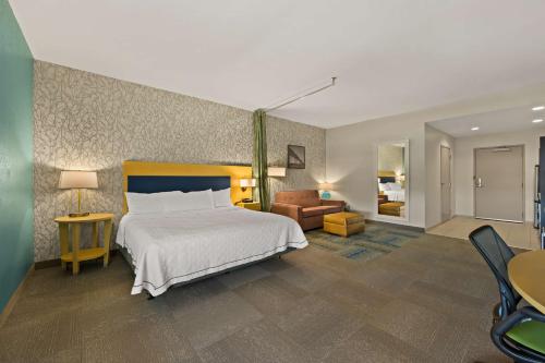 - une chambre avec un lit et un salon dans l'établissement Home2 Suites By Hilton Baytown, à Baytown