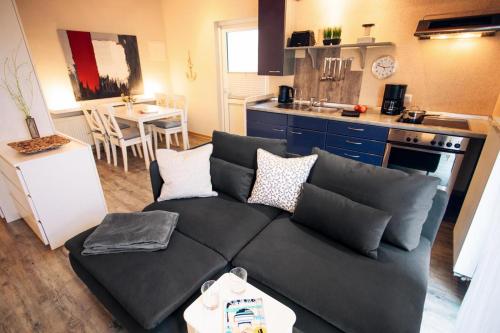 Il comprend un salon avec un canapé et une cuisine. dans l'établissement Haus Jelena Appartement 5, à Borkum