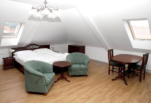 a bedroom with a bed and two chairs and a table at Pivovar a restaurace Faltus in Česká Třebová
