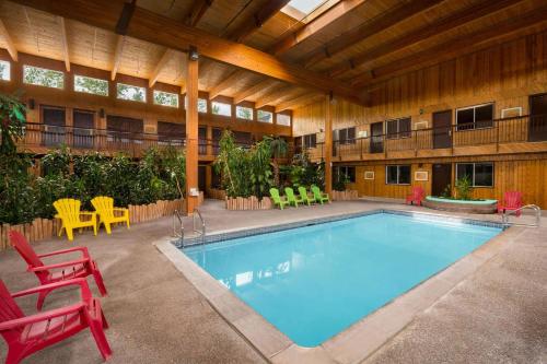a large swimming pool with chairs and a table at Super 8 by Wyndham Prince George in Prince George