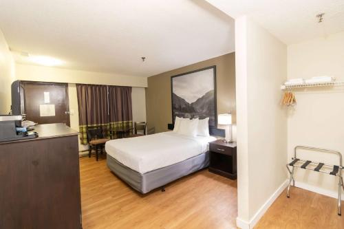 a hotel room with a bed and a desk at Super 8 by Wyndham Prince George in Prince George
