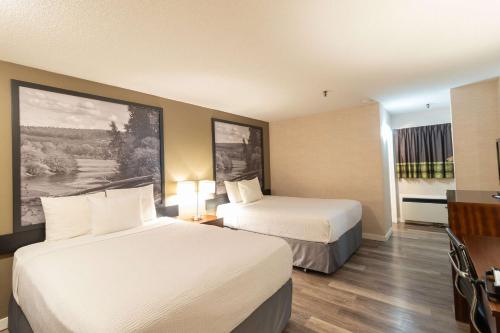 a hotel room with two beds and a television at Super 8 by Wyndham Prince George in Prince George
