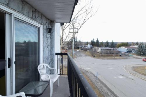 a white chair sitting on a balcony looking at a street at Super 8 by Wyndham Prince George in Prince George