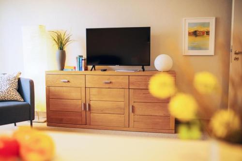 una sala de estar con TV en un tocador de madera en Haus Jelena Appartement 2 en Borkum