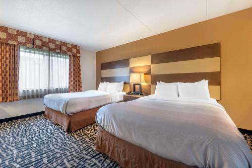 Habitación de hotel con 2 camas y ventana grande. en Quality Inn & Suites Mayo Clinic Area, en Rochester