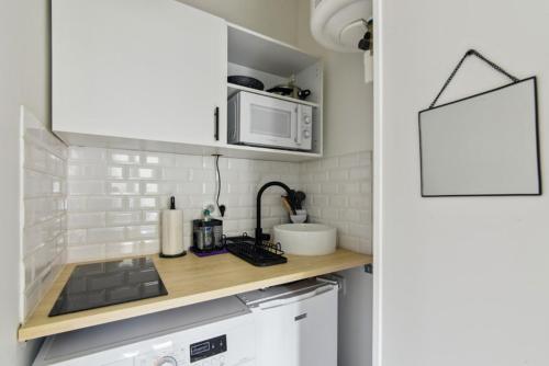 a kitchen with a counter top with a microwave at 821 Suite Licorne - Superb apartment in Les Lilas