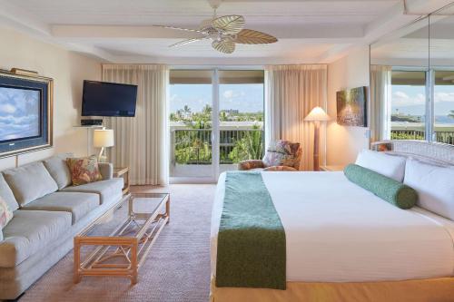 a hotel room with a bed and a couch at Aston at The Whaler on Kaanapali Beach in Lahaina