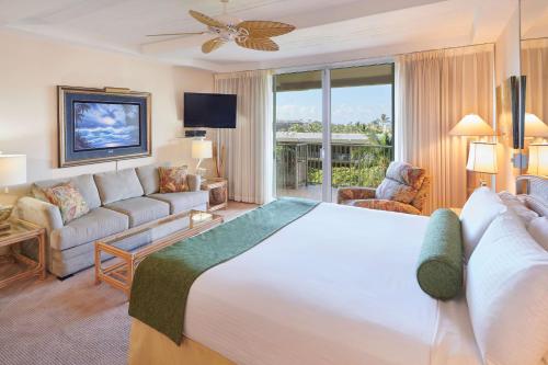 a hotel room with a large bed and a couch at Aston at The Whaler on Kaanapali Beach in Lahaina