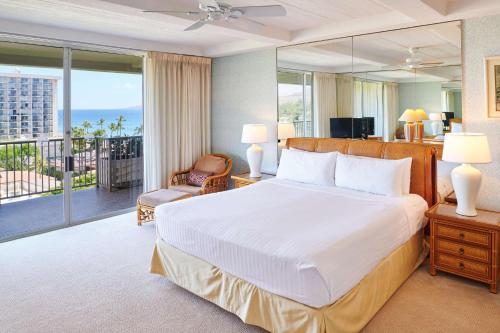 a bedroom with a large bed and a balcony at Aston at The Whaler on Kaanapali Beach in Lahaina