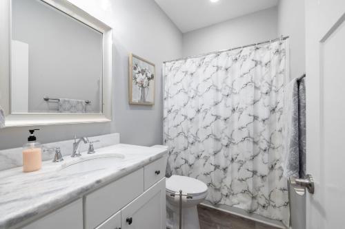 a white bathroom with a sink and a shower curtain at Cozy Lake Cottage W/ Kayaks, SUPs, Pool & Firepit in Winchester