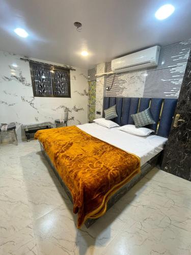 ein Schlafzimmer mit einem großen Bett mit einer orangefarbenen Decke in der Unterkunft Kashi Dham Home Stay in Varanasi