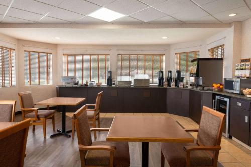 a restaurant with two tables and chairs and windows at Days Inn by Wyndham Swift Current in Swift Current