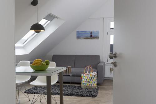 Haus Nordstern Wohnung 5 في بوركوم: غرفة معيشة مع أريكة وطاولة