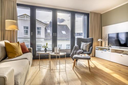 ein Wohnzimmer mit einem Sofa und einem TV in der Unterkunft Sparkassengebäude Wohnung 5 in Borkum