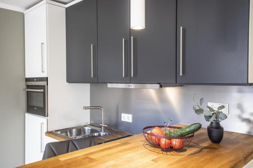 a kitchen counter with a bowl of fruit and a sink at Sparkassengebäude Wohnung 5 in Borkum