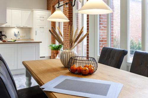 a dining room table with a basket of oranges on it at Commandeur-Huus Wohnung 1 in Borkum